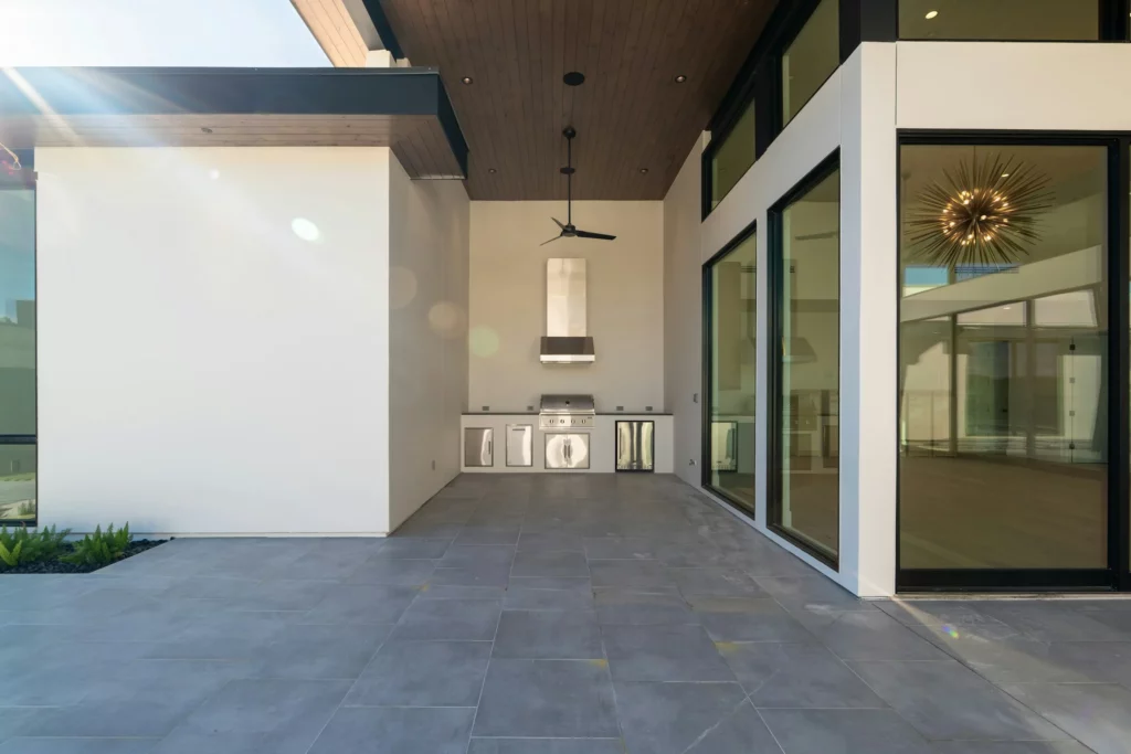 Covered outdoor kitchen with a stone countertop and built-in grill