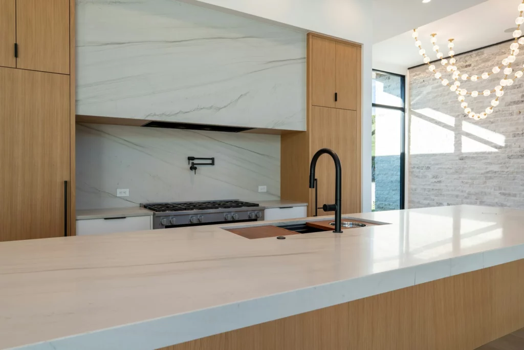 White porcelain slab island and full-height backsplash